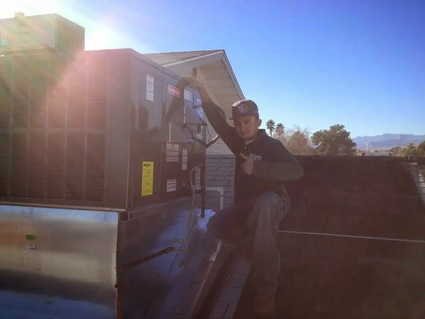 HVAC technician performing HVAC Inspection on a rooftop unit in Goshen